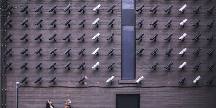 Dos personas frente a un negocio de sistemas de seguridad.