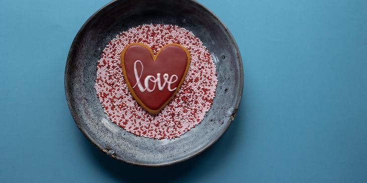 La palabra corta "amor" escrita sobre una galleta dulce en un plato de chispas.