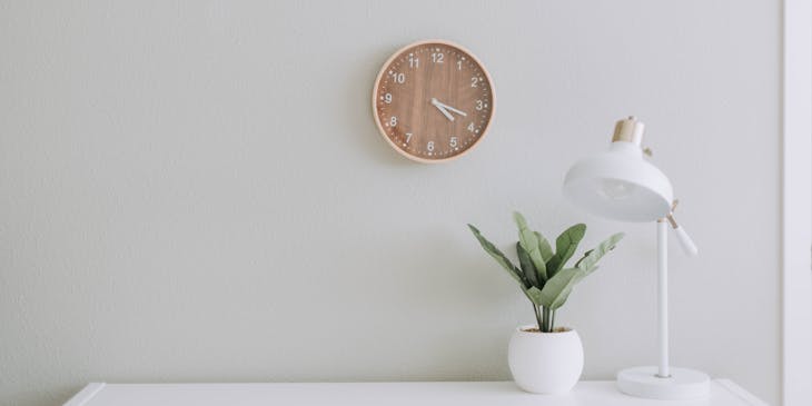 Uma lâmpada simples e uma planta em uma mesa branca.