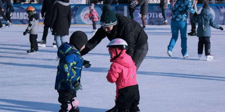 Niños patinando en una pista de patinaje de hielo.