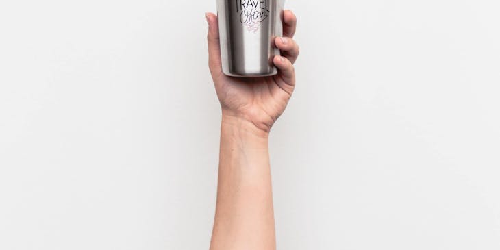 An outstretched arm holding a tumbler.