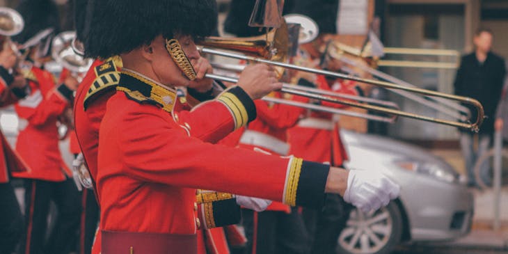 Men in red uniforms blowing trumpets.