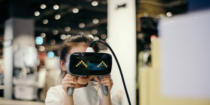 mujer joven mirando a través de unos lentes de realidad virtual