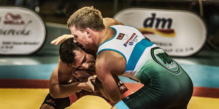 Dos hombres peleando en un combate de lucha libre.