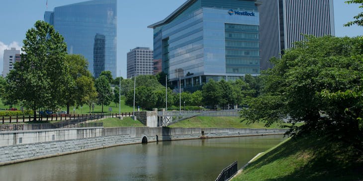 Corporate buildings lined with trees along a canal