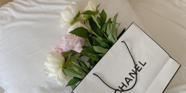 A gift bag with the two-syllable brand name "Chanel" displayed on it.